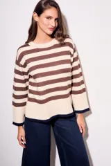 Sweater de punto a rayas horizontales negras y crudas, con cuello redondo y mangas largas. Tiene ribete marrón en puños y ruedo.