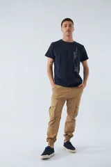 Pantalón cargo gris oscuro, corte slim, con cierre de botón y cremallera, trabillas para cinturón, bolsillos cargo con botón y puños ajustados.