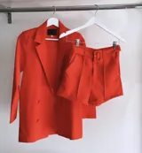 Short sastrero rojo con hebilla y bolsillos laterales.