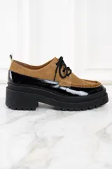 Mocasín abotinado con capellada combinada en cuero color marrón y charol negro.