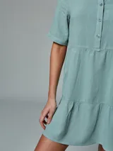 Vestido verde musgo con cuello camisero, manga corta y corte evasé.