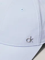 Gorra de béisbol de algodón en color celeste pálido, con visera curva y un pequeño herraje metálico con el logo 'ck' en la parte delantera.