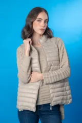 Chaleco acolchado color beige con cierre frontal y cuello alto.