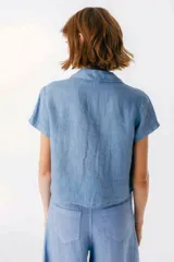 Camisa celeste de lino con cuello clásico, mangas cortas, corte crop y lazos en el frente.
