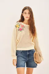Sweater color crema de algodón con tejido calado y bordado de flores en el hombro.