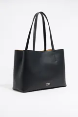Bolso shopper negro de cuero con textura granulada, doble asa de hombro y logo blanco estampado en la parte inferior. Interior color caramelo con bolsillo con cierre. Cierre superior con lazo de cuero.
