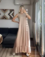 Vestido largo color beige, de tela tipo seda lisa, sin mangas y con volados en el ruedo.