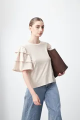 Remera de algodón color beige con cuello redondo y mangas cortas con diseño de volados en capas.