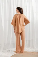 Pantalón de lino blanco, de corte ancho y tiro alto, con cintura elastizada y cordón ajustable.