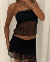 Top negro de encaje con escote recto y tirantes finos. La parte inferior del top es transparente con un patrón de ondas, terminando con un ruedo festoneado.