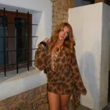 Minivestido marrón con estampado animal print, escote drapeado pronunciado y mangas largas acampanadas.