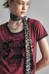 Remera color crema con cuello y mangas con ribete azul marino. Estampado frontal con la frase "Rock the Music" en letras negras con detalles de estrellas.