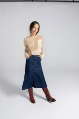 Falda midi de jean azul oscuro, corte evasé con paneles diagonales y dos bolsillos delanteros.