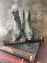 Bota corta verde de cuero con punta tejana y puntera con textura de piel de pitón.