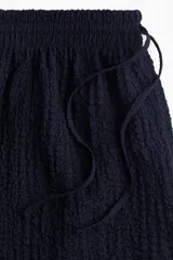 Short azul marino de punto arrugado con cintura elástica y cordón ajustable.