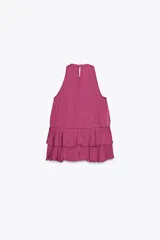 Top color fucsia de cuello halter con volantes en el mismo tejido. Cierre en la espalda con abertura y botones.