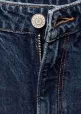 Pantalón de jean azul oscuro de corte slouchy, tiro alto y cinco bolsillos.