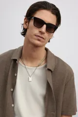Camisa marrón de punto con textura, corte regular, cuello inglés, tapeta lisa, canesú en la espalda, bajo recto con aberturas laterales y manga corta.
