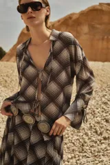 Camisa marrón con estampado escocés a cuadros, de corte holgado, con cuello camisero y lazos en el escote.