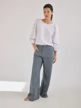 Remera gris de algodón con mangas color beige con bordados de líneas en blanco, amarillo y gris.