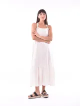Vestido largo color crudo, con breteles finos y volados en el ruedo.