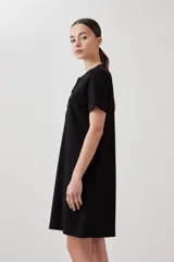 Vestido midi negro de corte recto, con cuello redondo y botones frontales.