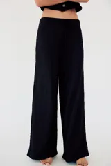 Pantalón de vestir color crudo, de tiro alto, corte recto y textura arrugada. Cuenta con cintura elástica ajustable con cordones.