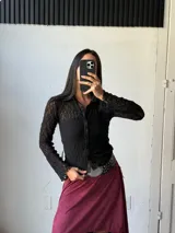 Camisa de encaje negra con cuello clásico y botones frontales.