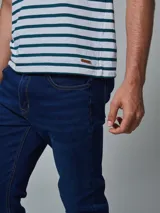 Remera de algodón blanca con rayas horizontales verdes y cuello redondo.