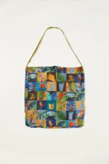 Bolso tipo tote bag con estampado de motivos selváticos en tonos azules, verdes, naranjas y amarillos. Se puede usar como pareo.