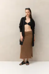 Falda larga de tejido de punto marrón con sutil brillo metalizado y tajo lateral.