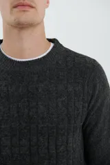 Sweater gris oscuro de tejido de punto trenzado, con cuello redondo y mangas largas.
