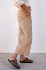 Pantalón capri color beige de pana con tiro alto, corte ancho y bolsillos laterales.