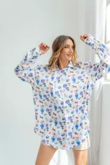 Camisa blanca con estampado de flores, perros, sillas y jarrones.