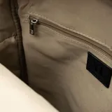 Mochila negra de cuero sintético con diseño acolchado vertical, doble asa de mano y correas regulables. Tiene dos bolsillos externos con cierre, un compartimento principal con cierre, un bolsillo interno con cierre y dos bolsillos internos abiertos.