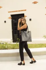 Bolso de cuero negro con textura de cocodrilo y asas largas, de forma rectangular.