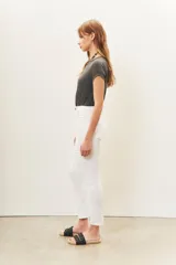 Pantalón jean blanco de tiro medio y calce slim, con largo al tobillo.