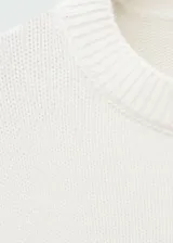 Sweater color crema de tejido de punto grueso con cuello redondo y mangas largas.