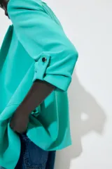 Blazer marrón con cuello solapa y hombreras. Manga tres cuartos con trabilla y botón dorado. Bolsillos delanteros con solapa.