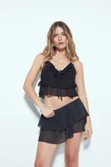 Falda corta negra con volados escalonados y cintura lisa.