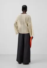 Jersey de punto malla color crema, con cuello en V y mangas largas japonesas.