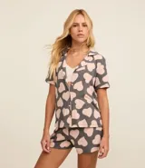 Conjunto de pijama americano corto confeccionado en viscosa certificada, compuesto por una blusa de manga corta con cuello solapa y abotonado delantero, y un short con cintura elástica y lazo. Estampado de corazones.