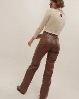 Pantalón de eco-cuero marrón, con corte ajustado y diseño contemporáneo.