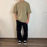 Remera negra con estampado de hongos y texto en la espalda, corte oversize.