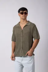 Camisa color verde militar tejida con calado aireado, de manga corta, cuello bowling y botones al tono.