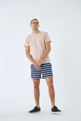 Short de baño azul con estampado de hojas y flores en blanco. Tiene cintura elástica con cordón ajustable, dos bolsillos laterales y uno trasero.