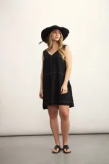 Vestido corto color negro, sin mangas, con escote en V y bolsillos laterales.