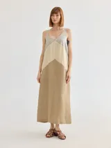 Vestido largo de lino color beige, con corte evasé, breteles finos y escote en V.