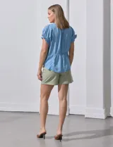Blusa celeste de lyocell, con cuello a la base y escote en V. Manga corta con detalle de punto smock. Marca Zac & Rachel.