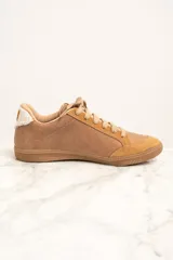 Zapatillas bajas color marrón con detalles en cuero con estampado de vaca en los laterales y talón.